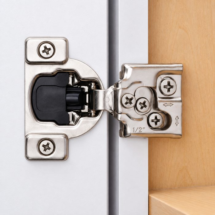 Decobasics half-inch overlay hinge installed in a wood cabinet